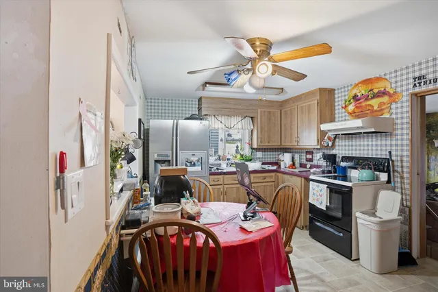 a kitchen with stainless steel appliances granite countertop a stove top oven a refrigerator and a dining table