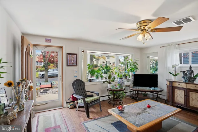 a living room with furniture a flat screen tv and a floor to ceiling window