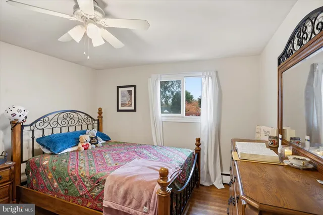 a bedroom with a bed a chandelier and dresser