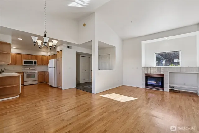 a view of a livingroom with a fireplace a chandelier and wooden floor