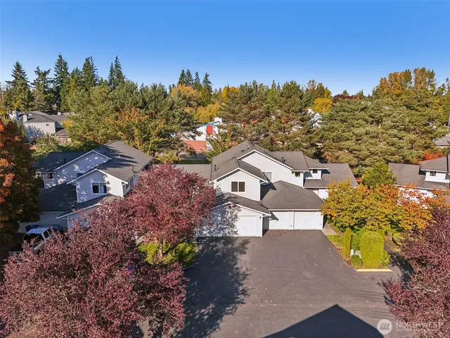 a view of a house with a big yard and large trees