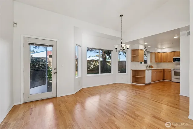 a view of a kitchen with wooden floor and a window