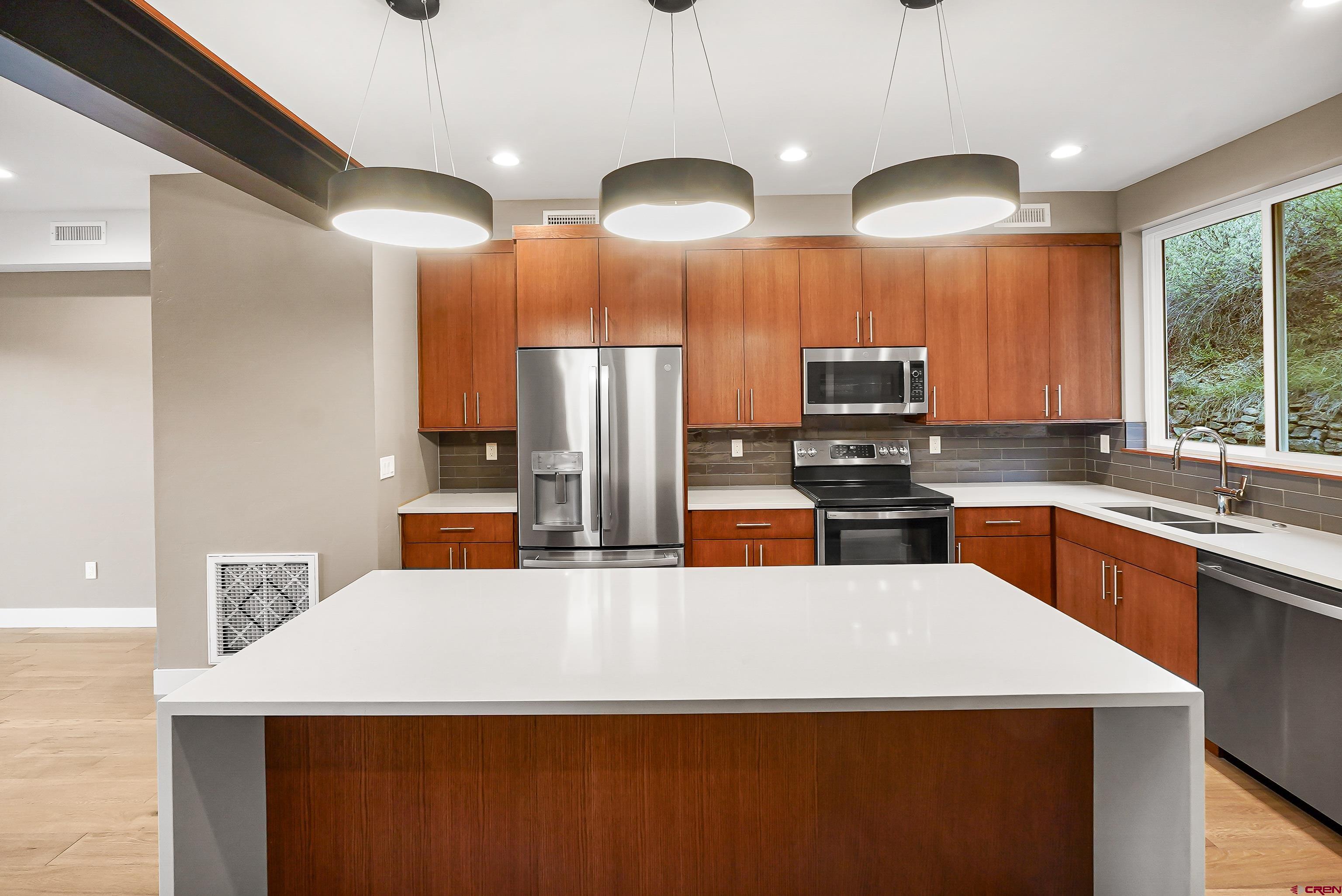 762 Goeglein Gulch Road, Unit 5 Durango, CO 81301 - Photo 3 of 43 a kitchen with stainless steel appliances a refrigerator a sink a stove a center island a stove and a sink
