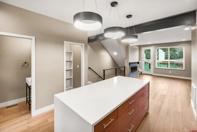 a kitchen with kitchen island a counter top space appliances and a ceiling fan