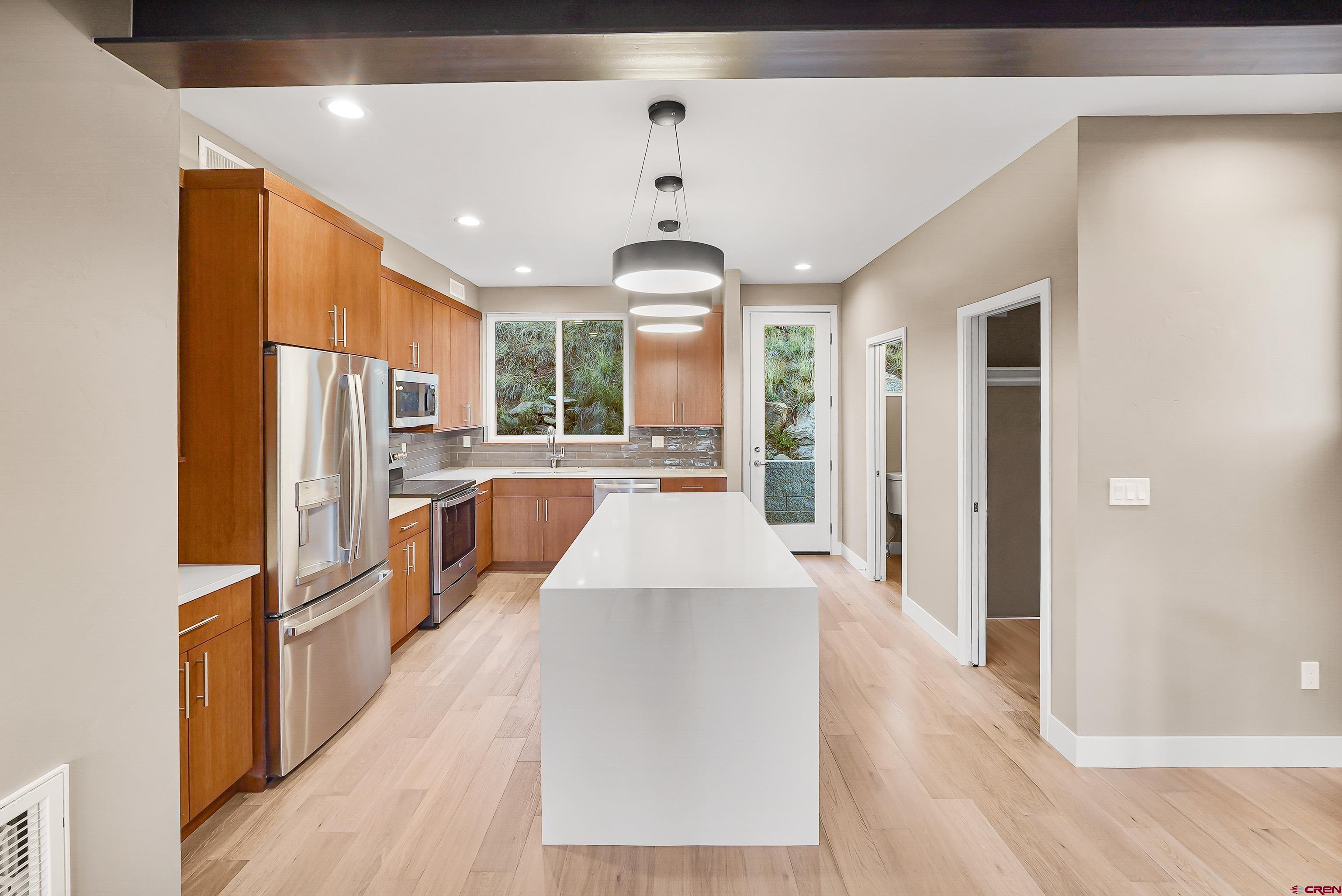 762 Goeglein Gulch Road, Unit 5 Durango, CO 81301 - Photo 6 of 43 a large kitchen with stainless steel appliances granite countertop a refrigerator a oven a stove and a wooden floors