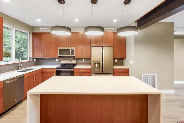 a large kitchen with kitchen island a large island in it