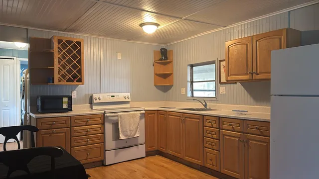 a view of a refrigerator in a hall with wooden floor