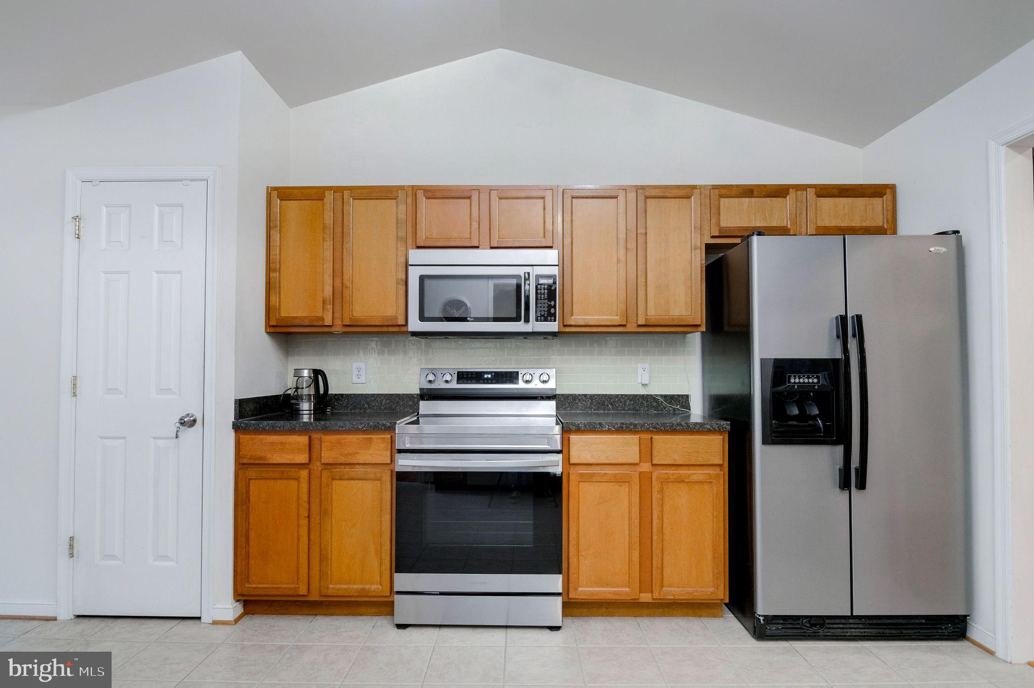 405 Harrison Circle Locust Grove, VA 22508 - Photo 12 of 33 a kitchen with stainless steel appliances a refrigerator a stove a microwave and cabinets