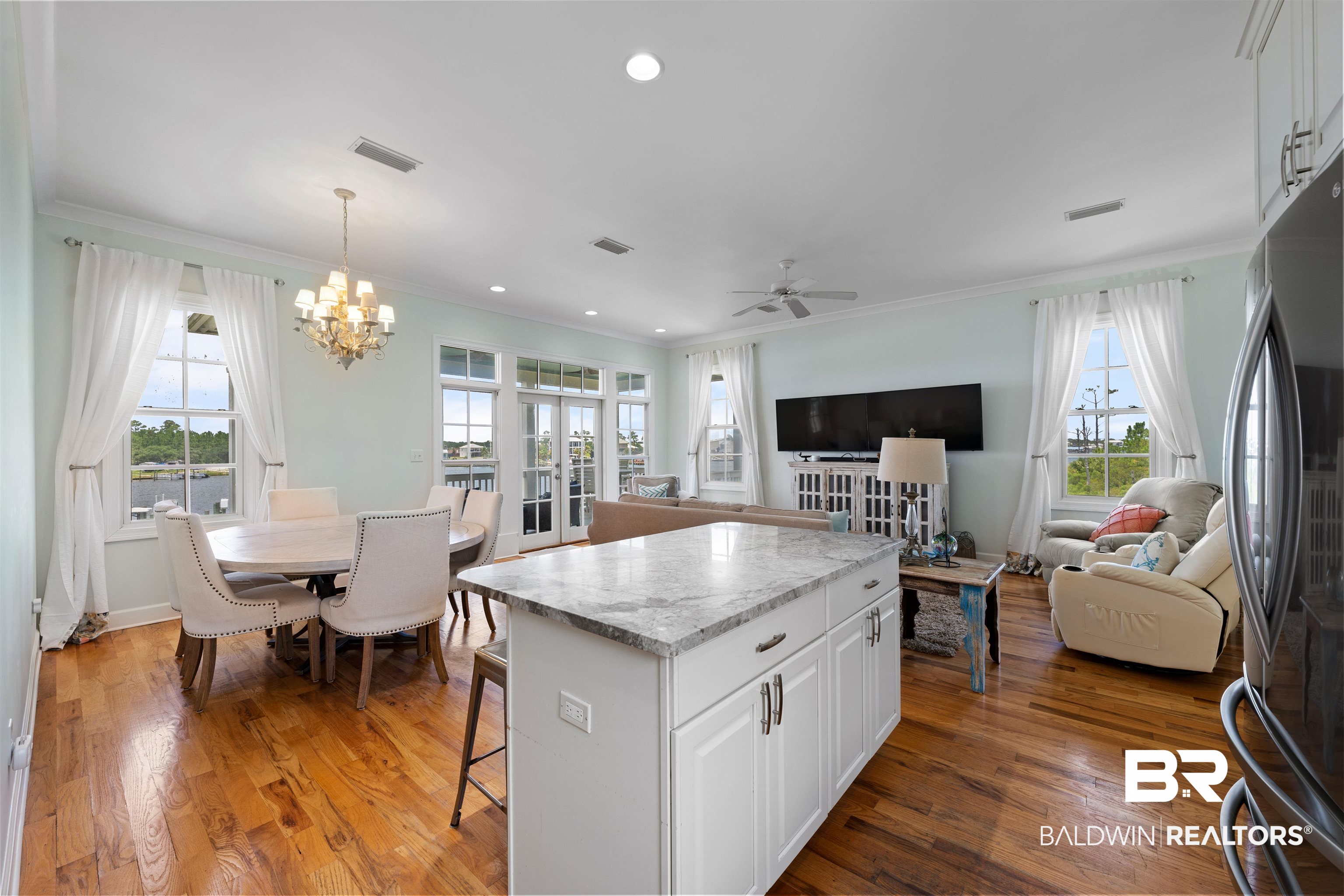 3434 Mariner Circle Orange Beach, AL 36561 - Photo 20 of 38 Kitchen with white cabinetry, black refrigerator, hardwood / wood-style floors, and a wealth of natural light