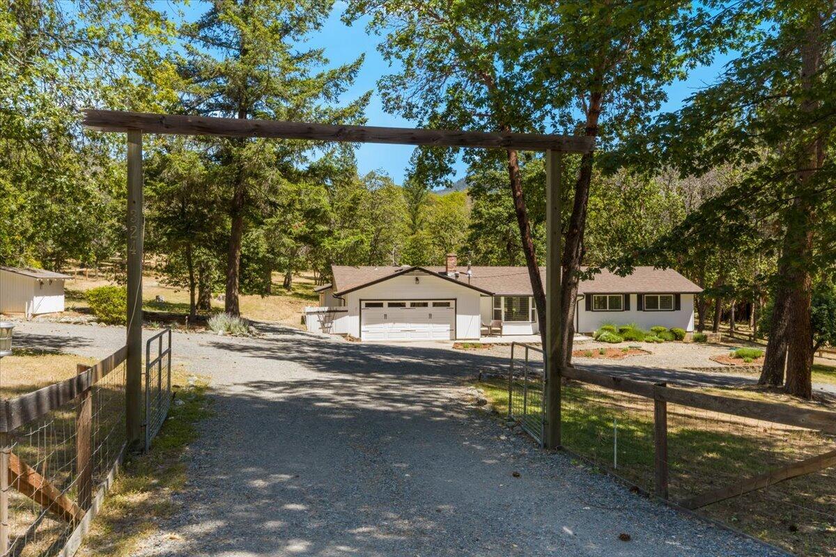 324 China Gulch Road Jacksonville, OR 97530 - Photo 1 of 45 a front view of a house with a yard and trees