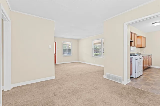 an empty room with windows and cabinet