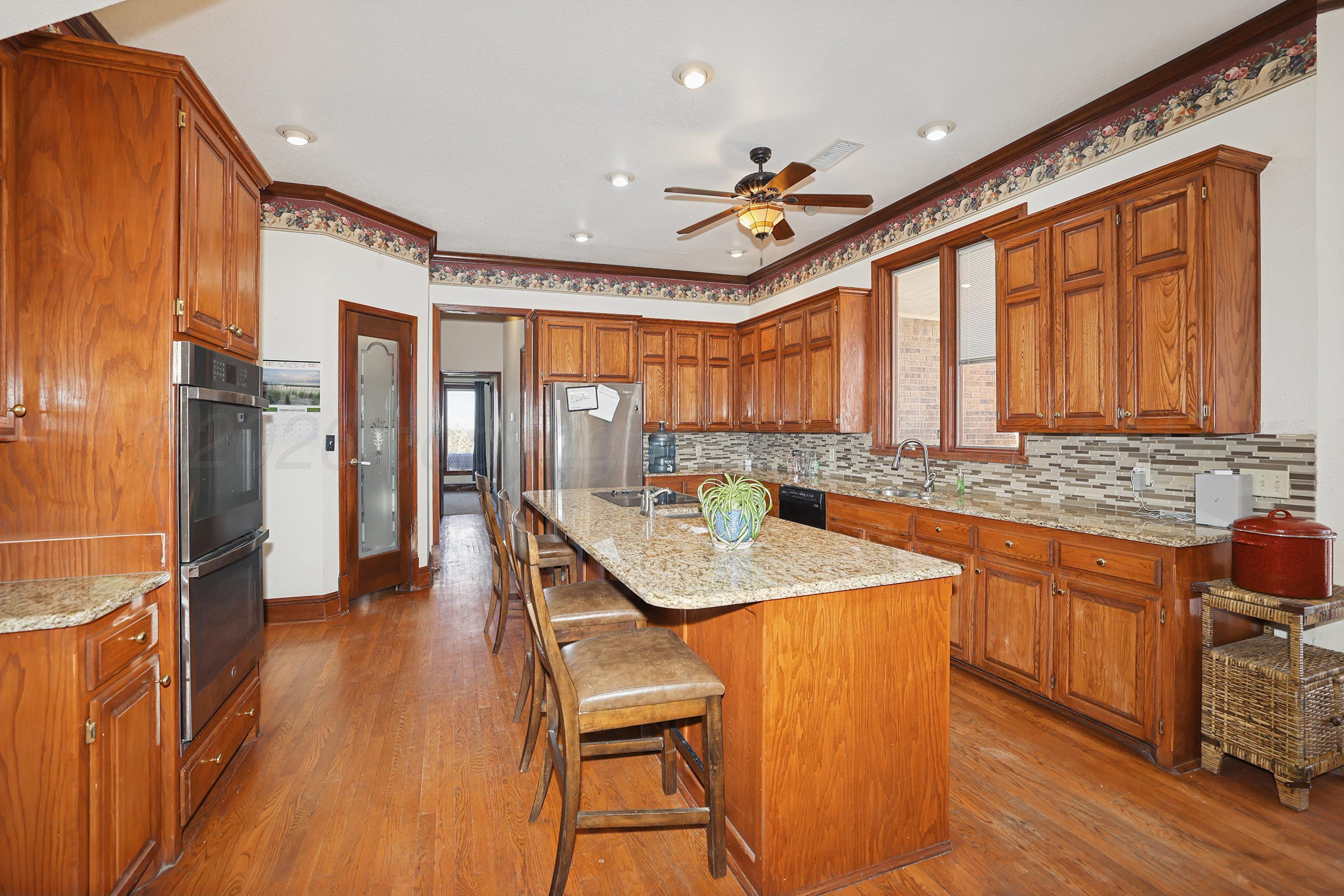 a dining hall with stainless steel appliances granite countertop a granite counter tops and a view of living room