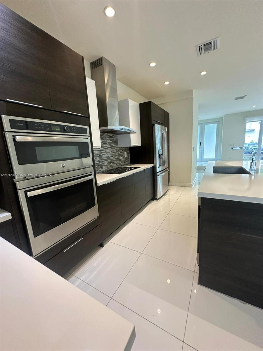10363 Northwest 63rd Terrace Miami, FL 33178 - Photo 1 of 34 a kitchen with kitchen island granite countertop a stove and a sink