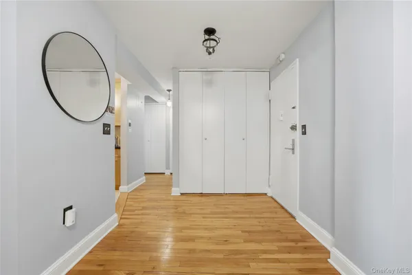 a view of a hallway with wooden floor and entryway