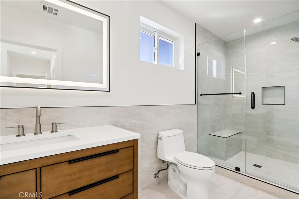 14931 Vose Street Van Nuys, CA 91405 - Photo 28 of 51 a bathroom with a sink a toilet a mirror and shower