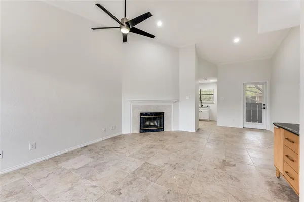 an empty room with windows and fireplace