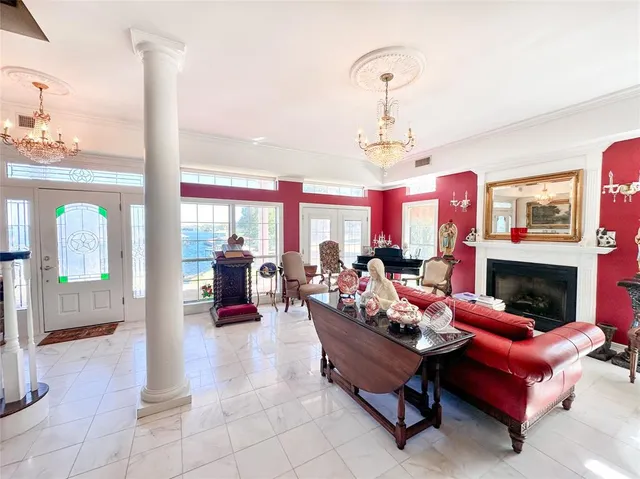 a living room with furniture a fireplace and a chandelier