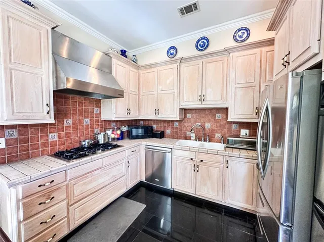 a kitchen with stainless steel appliances a white cabinets and a stove