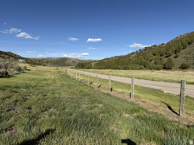 2006 Swenson Valley Road Bancroft, ID 83217 - Photo 13 of 51 Expansive open landscape featuring a gravel road, wire fencing, and distant hills with scattered trees
