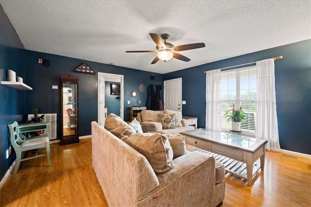 520 Sharon Lane Seneca, SC 29678 - Photo 8 of 48 An inviting living area with warm wood flooring and a refreshing ceiling fan.