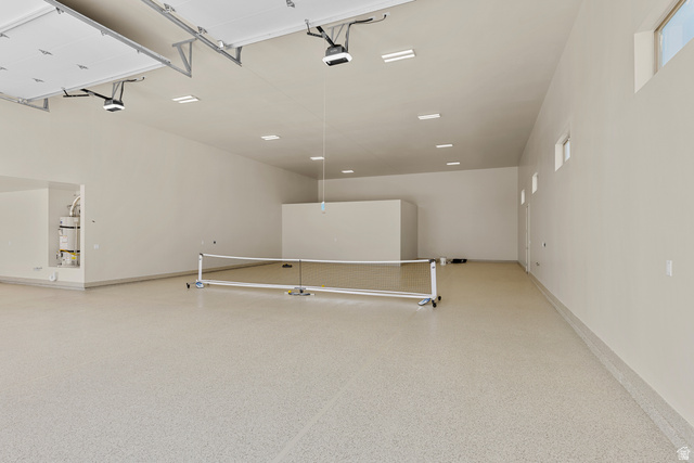 2955 East Rimrunner Drive St. George, UT 84790 - Photo 18 of 35 Expansive multi-car garage featuring a light-colored epoxy floor, multiple overhead garage door openers, recessed ceiling lighting, and high-set windows providing ambient illumination