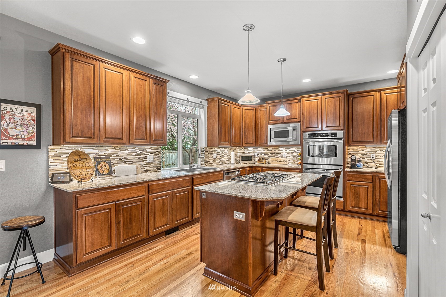 22404 5th Place West Bothell, WA 98021 - Photo 16 of 40 a kitchen with granite countertop wooden cabinets a center island and appliances