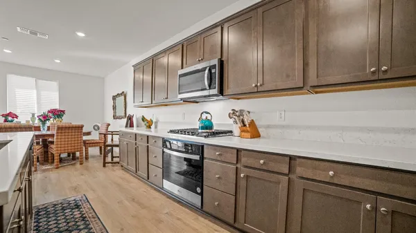 a kitchen with stainless steel appliances granite countertop a sink stove and cabinets