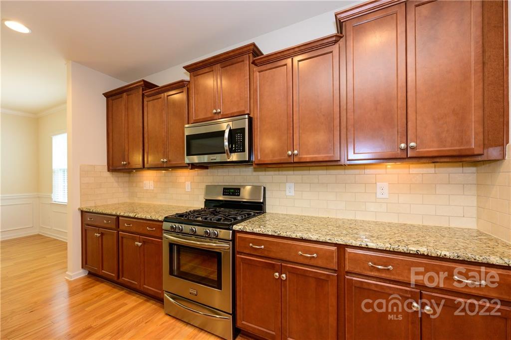 4241 Perth Road Indian Land, SC 29707 - Photo 9 of 34 a kitchen with granite countertop wooden cabinets and stainless steel appliances