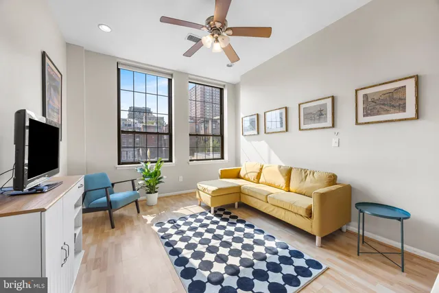 a living room with furniture a flat screen tv and a window