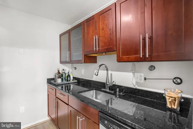 a kitchen with granite countertop a sink stove and cabinets