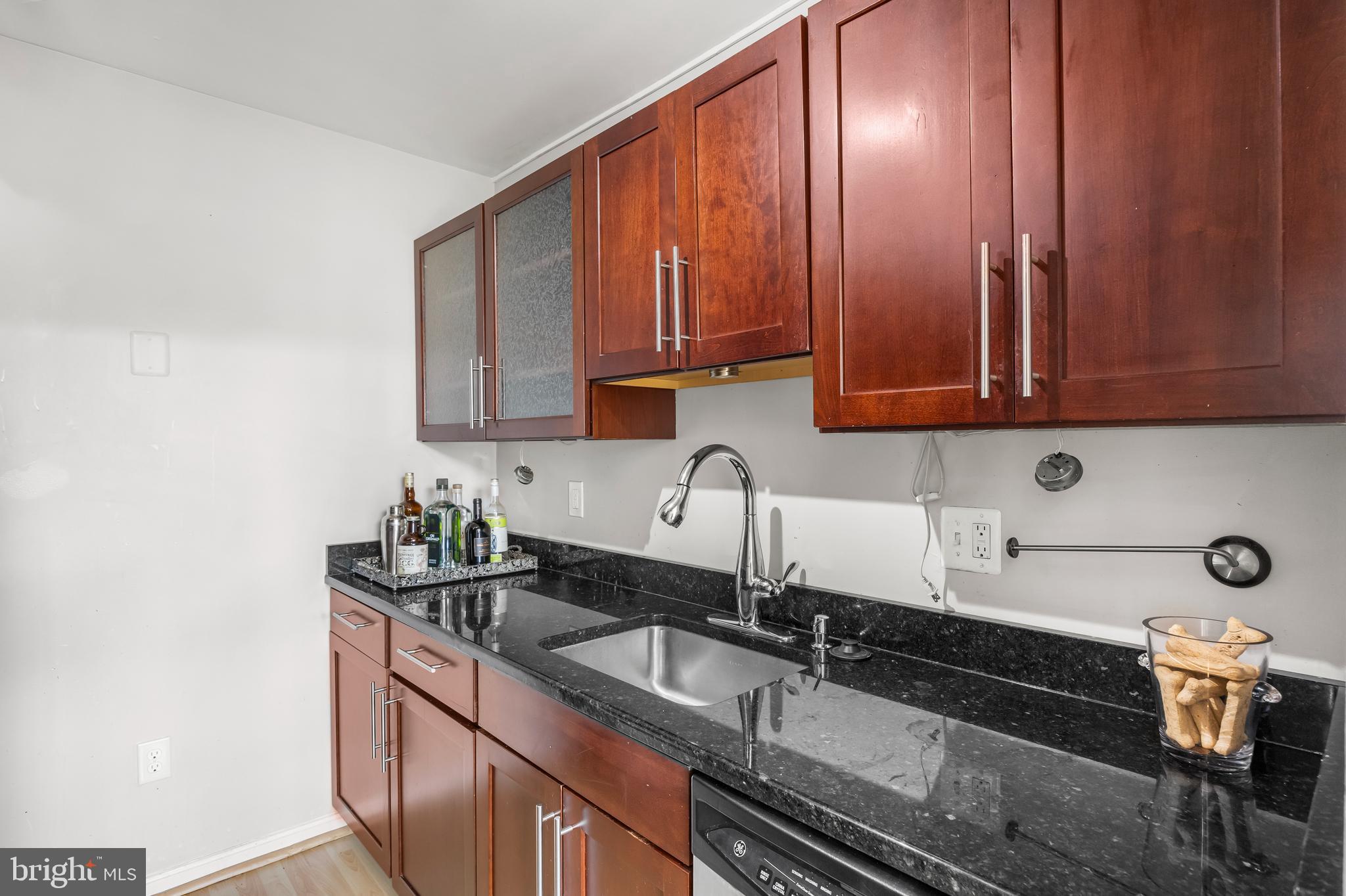 1011 Hunter Street, Unit F4 Baltimore, MD 21202 - Photo 9 of 19 a kitchen with granite countertop a sink stove and cabinets