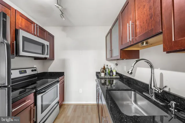 a kitchen with stainless steel appliances granite countertop a sink stove and microwave