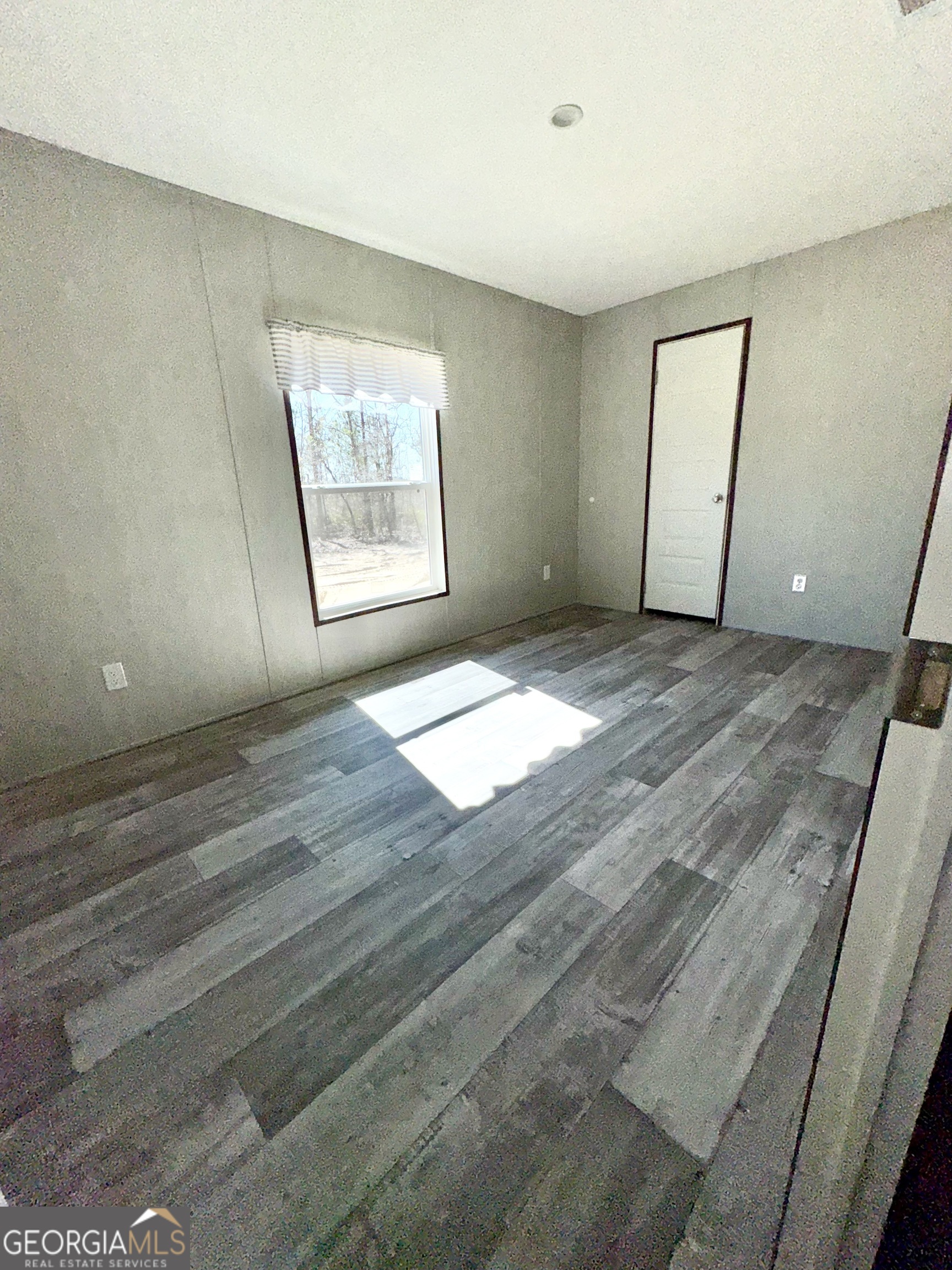 420 Mosley Bridge Road Claxton, GA 30417 - Photo 16 of 23 a view of an empty room with wooden floor and a window