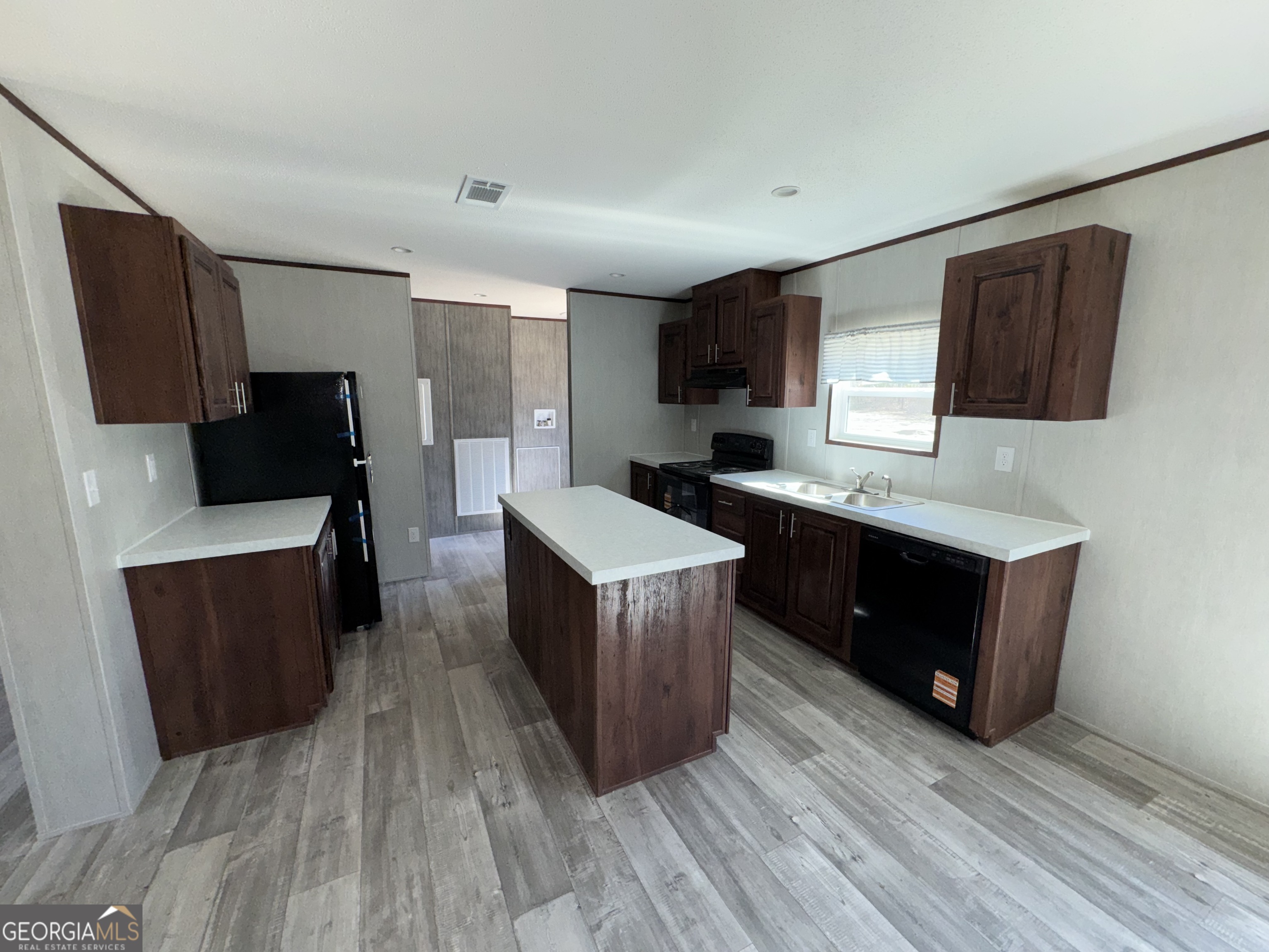 420 Mosley Bridge Road Claxton, GA 30417 - Photo 4 of 23 a kitchen with a sink wooden floor and black appliances