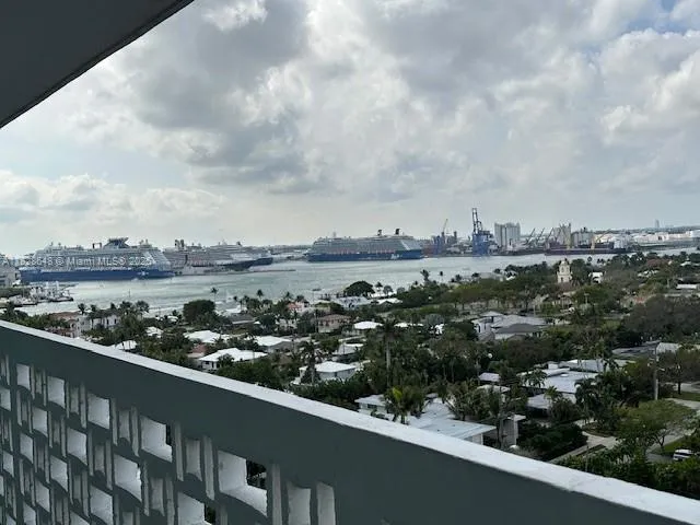 an aerial view of a city with lots of residential buildings ocean and mountain view in back