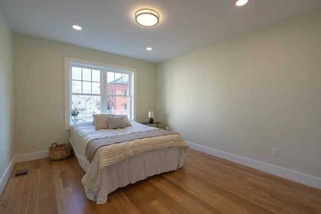 a bedroom with a bed and wooden floor