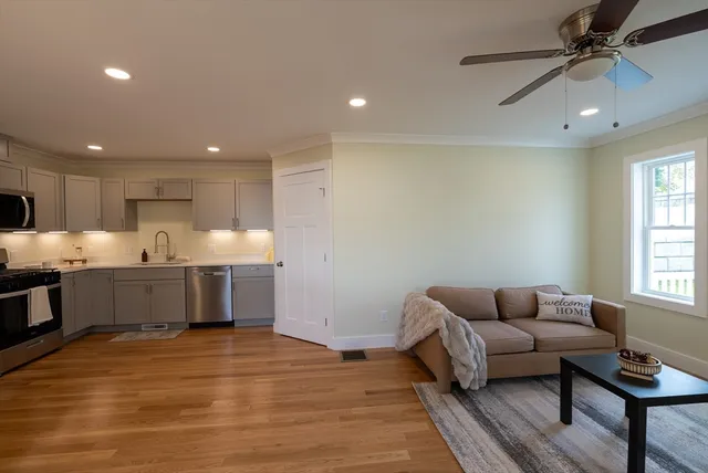 a living room with stainless steel appliances furniture and a window