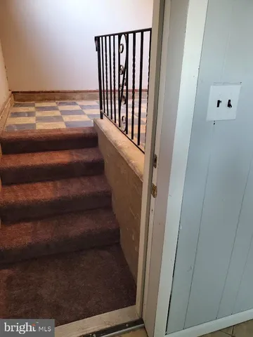 a view of staircase with white walls and a window