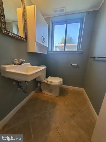 a bathroom with a sink a toilet and a window