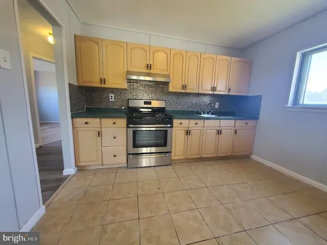 a kitchen with stainless steel appliances granite countertop a stove a refrigerator and a sink