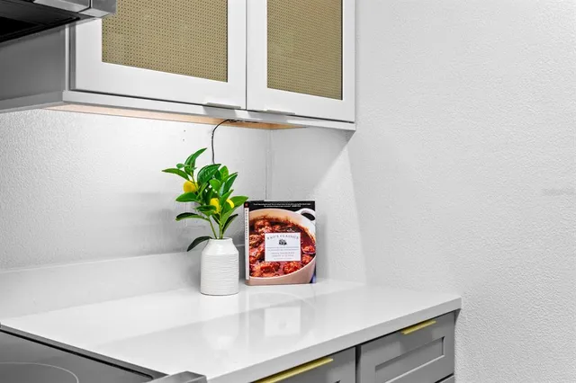 a kitchen with stainless steel appliances white cabinets and a stove top oven