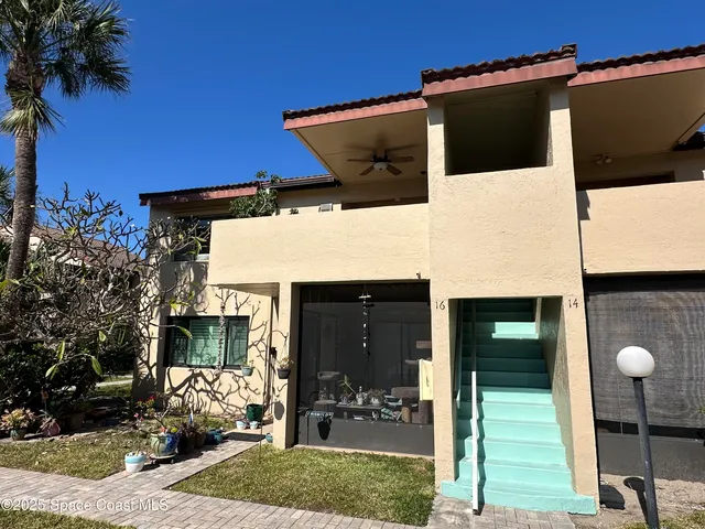 a view of a house with a yard and potted plants