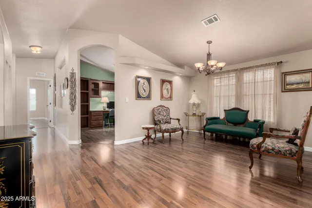 a living room with furniture a chandelier a fireplace and a window