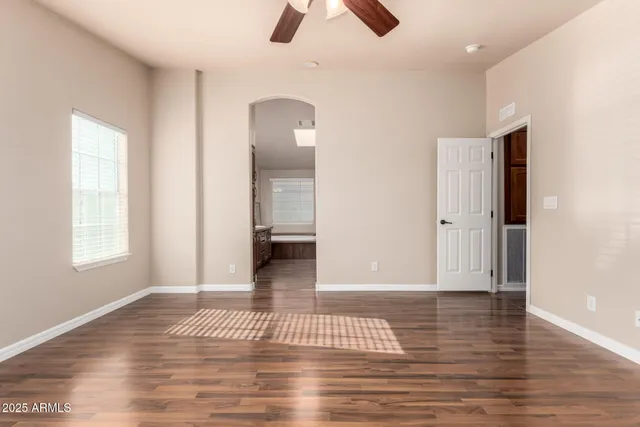 a view of empty room with wooden floor and window