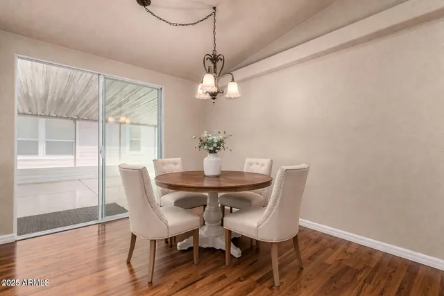 a dining room with furniture a chandelier and wooden floor