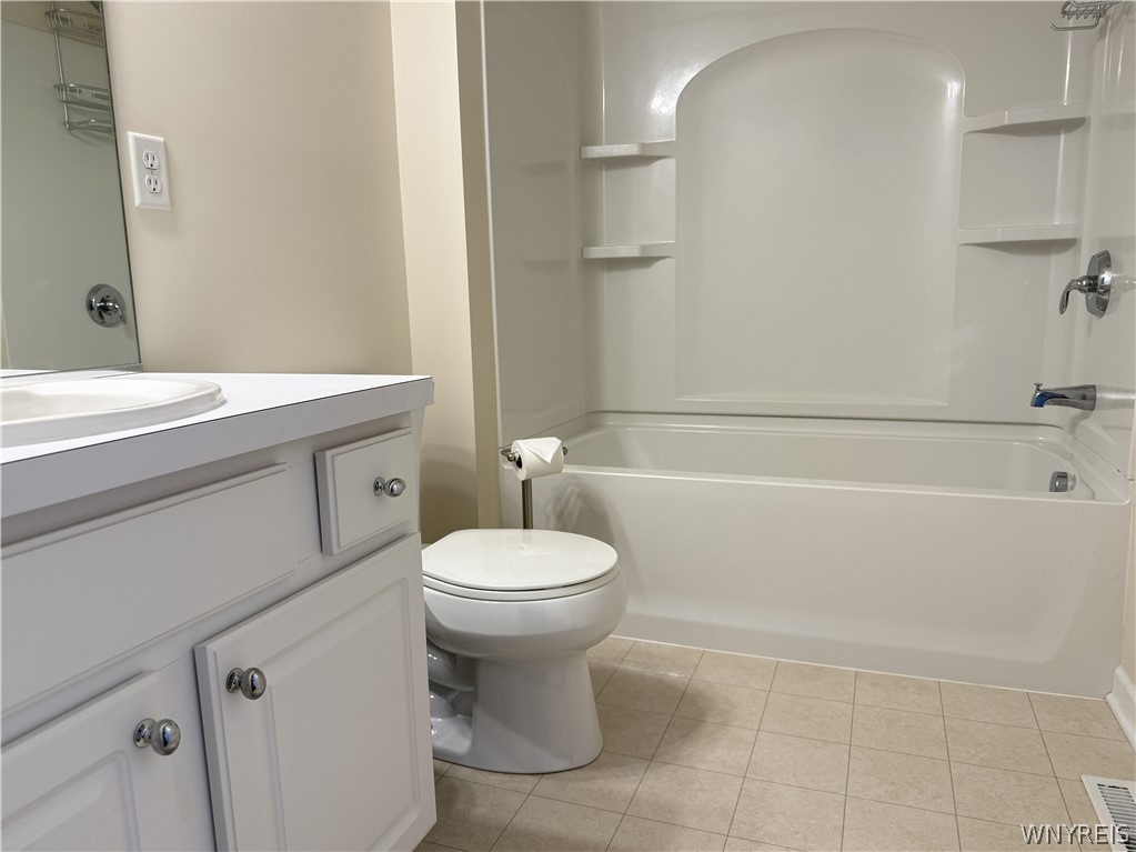 73 Chestnut Lancaster, NY 14086 - Photo 32 of 41 Tiled flooring and a molded shower-tub surround define this functional bathroom space.