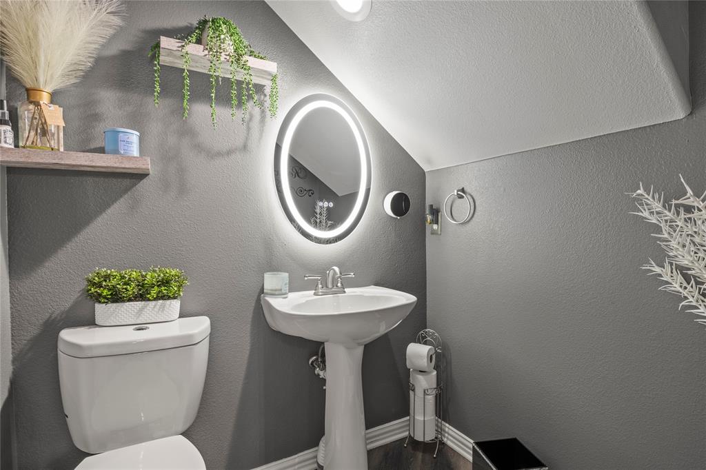 8342 Timberbrook Lane Dallas, TX 75249 - Photo 11 of 25 a bathroom with a toilet sink and mirror