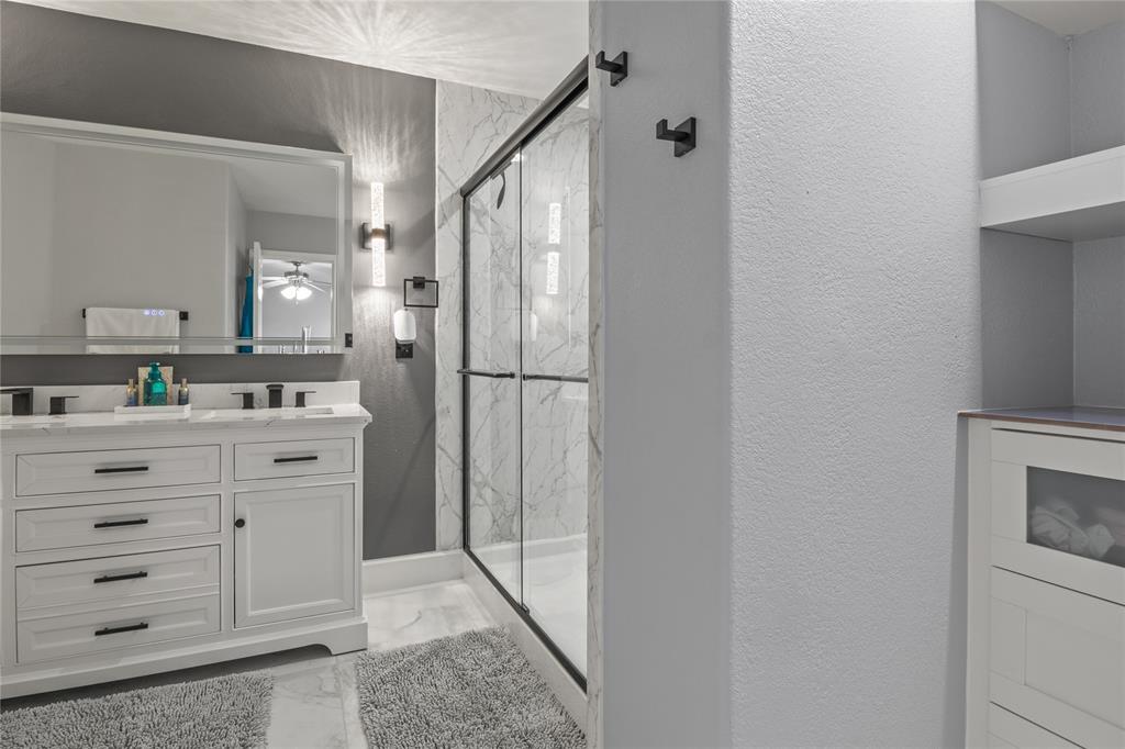 8342 Timberbrook Lane Dallas, TX 75249 - Photo 14 of 25 a bathroom with a shower sink and mirror