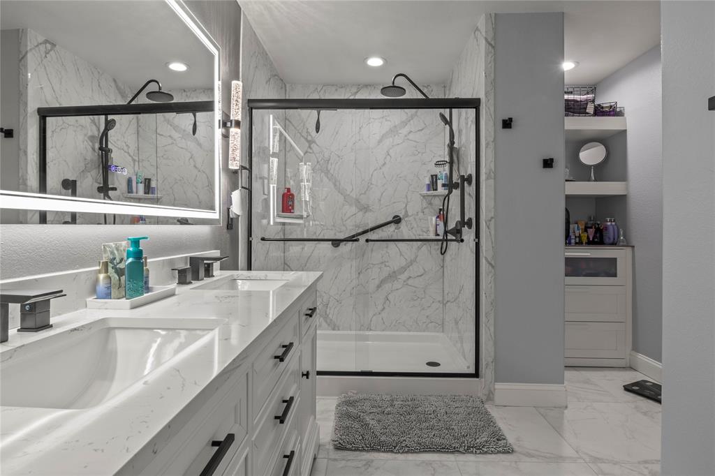8342 Timberbrook Lane Dallas, TX 75249 - Photo 16 of 25 a bathroom with a double vanity sink a mirror and shower
