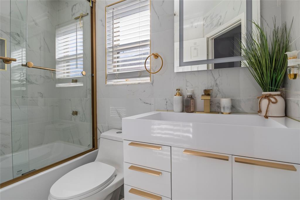 8342 Timberbrook Lane Dallas, TX 75249 - Photo 17 of 25 a bathroom with a sink a toilet and shower